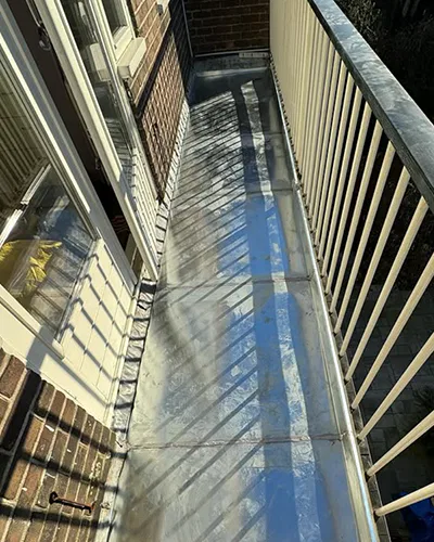 Balkon voorzien van nieuwe zinken bekleding in De Tuinen, Houten